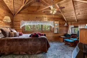 A cozy bedroom with a comfortable bed and a ceiling fan providing a cool breeze.